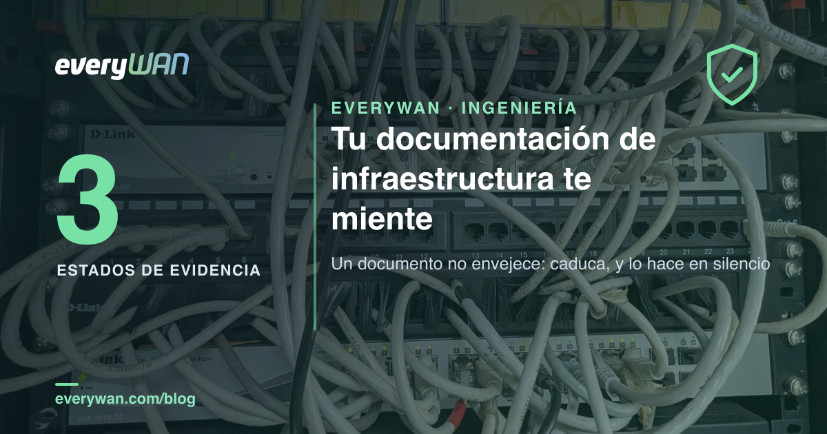 Sala de servidores en penumbra con un armario de red abierto y una etiqueta de inventario despegada colgando de un cable